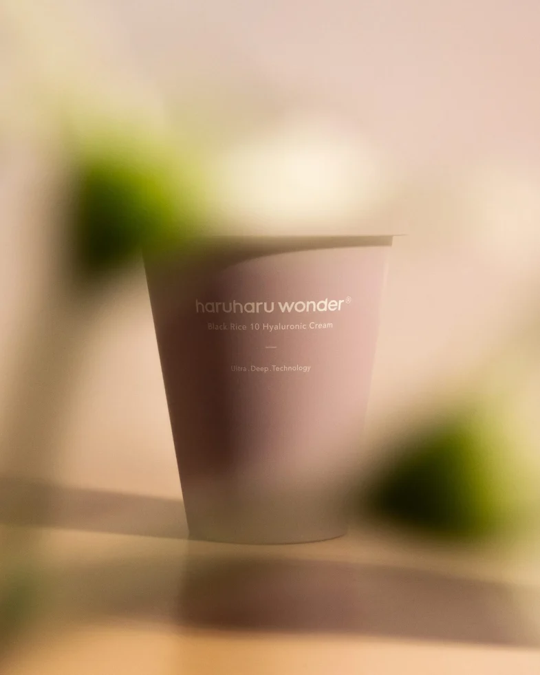 Krema Haruharu Wonder s oznakom Black Rice 10 Hyaluronic Cream, predstavljena u mekanom svjetlu, simbolizira divote cosmetics i korejsku kozmetiku.