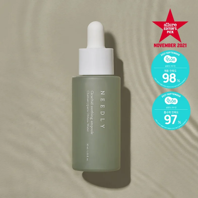 Zelena boca sa pipetom, na kojoj piše 'NEEDLY Cica Relief Soothing Ampoule', smještena na bež pozadini, okružena nagradom 'Allure Editor's Pick' i oznakama visokog zadovoljstva korisnika, simbolizirajući divote cosmetics i popularnost korejske kozmetike.
