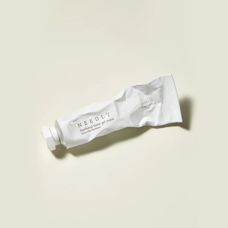 Ambalaža kreme za lice brenda Needly, koji pripada divote cosmetics liniji, poznat po korejskoj kozmetici, na svijetloj pozadini.