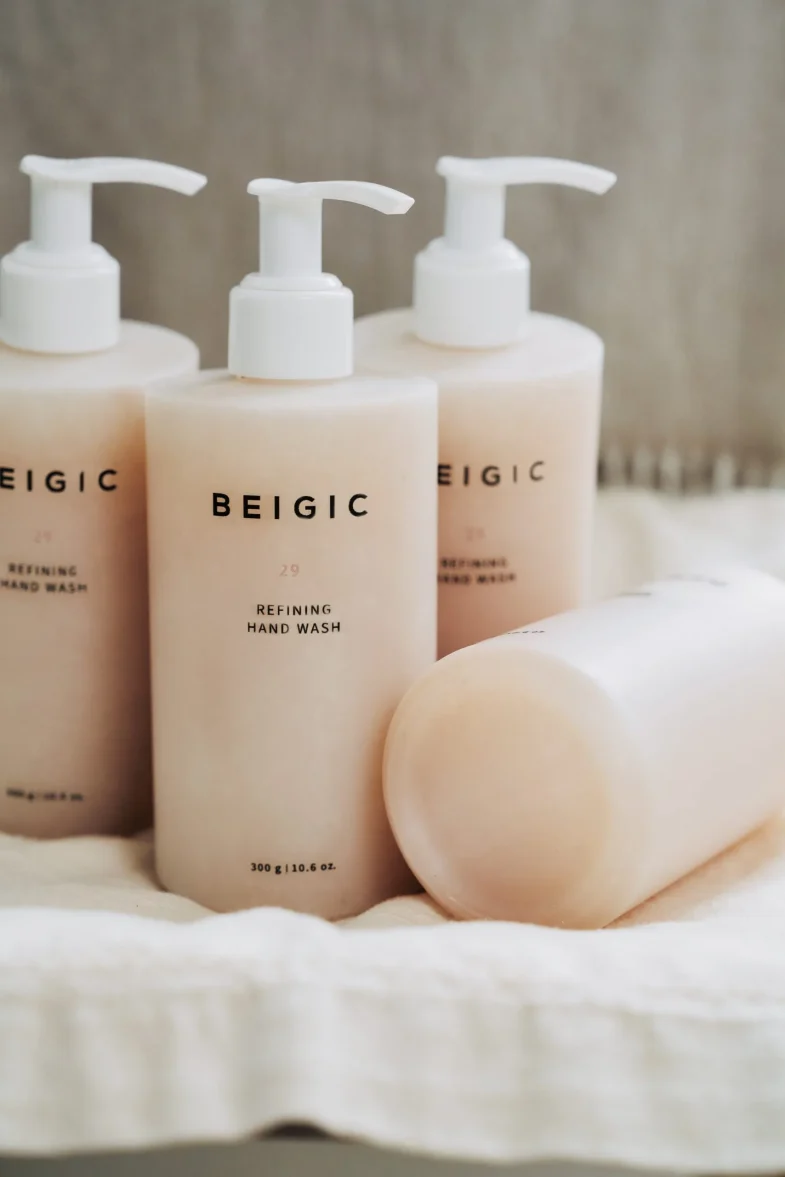 Bočice Divote Cosmetics Refining Hand Wash, popularne korejske kozmetike, uredno složene na krem platnu.