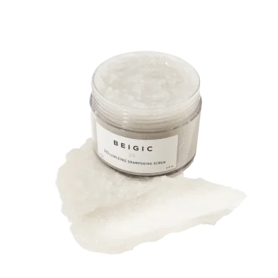 Staklenka proizvoda 'Beigic Volumizing Shampooing Scrub' s teksturom pilinga vidljivom vani, primjer korejske kozmetike i proizvoda iz 'divote cosmetics' linije.