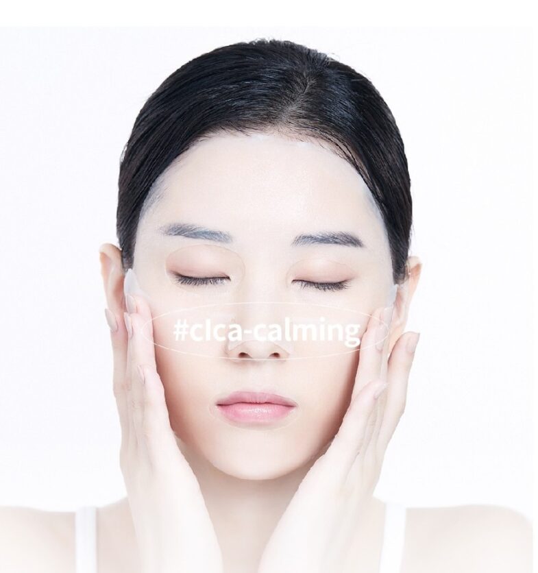 Žena zatvorenih očiju nanosi korejski kozmetički proizvod Divote Cosmetics s oznakom #clca-calming na licu.