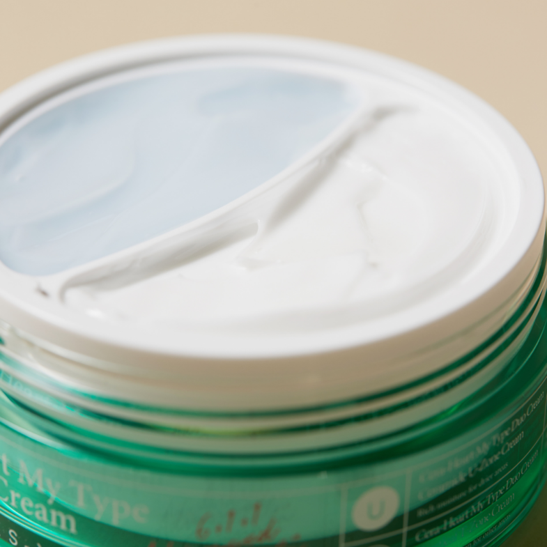 Zelena posudica s etiketom na kojoj se nalazi naziv proizvoda "Divote Cosmetics", puni se kremom iz kategorije korejske kozmetike.