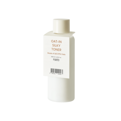 Bijela bočica s natpisom 'Oat-In Silky Toner' marke Purito, primjer korejske kozmetike, simbol je divote cosmetics s 68,09% ekstrakta zobi na etiketi.