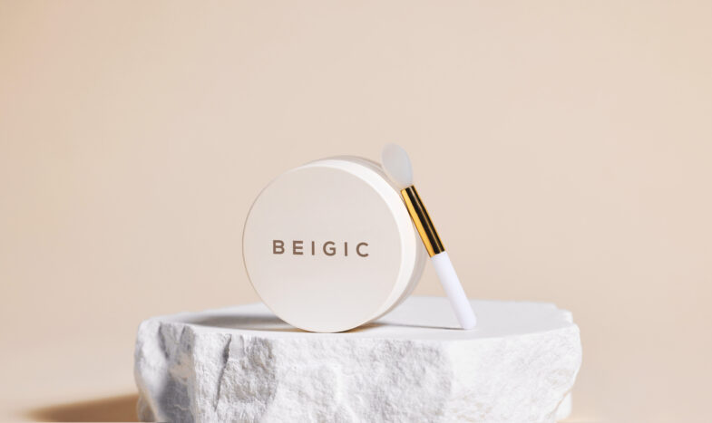 Beigič proizvod s aplikatorom stoji na kamenom postolju, ističući korejsku kozmetiku brenda Divote Cosmetics.