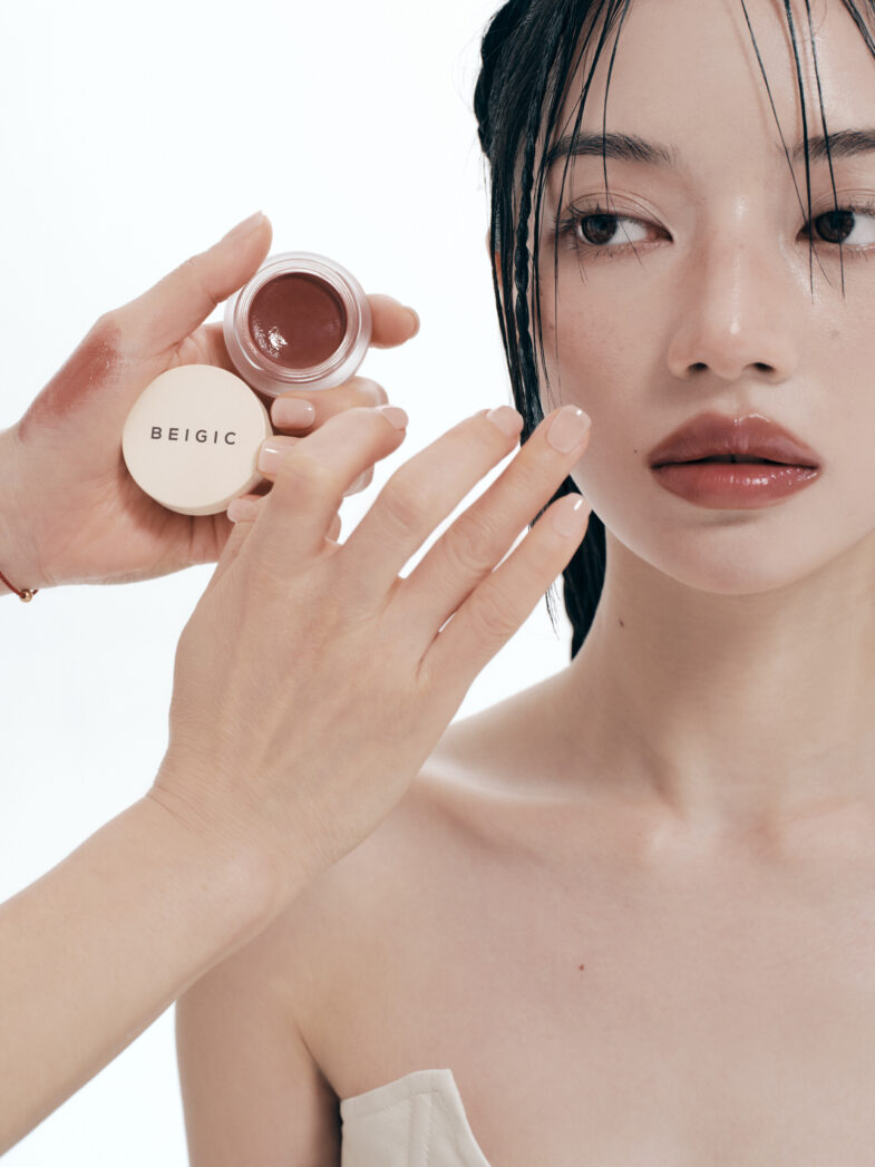 Žena se šminka koristeći korejsku kozmetiku brenda BEIGIC, što je primjer divote cosmetics, prikazano u elegantnom beauty kontekstu.