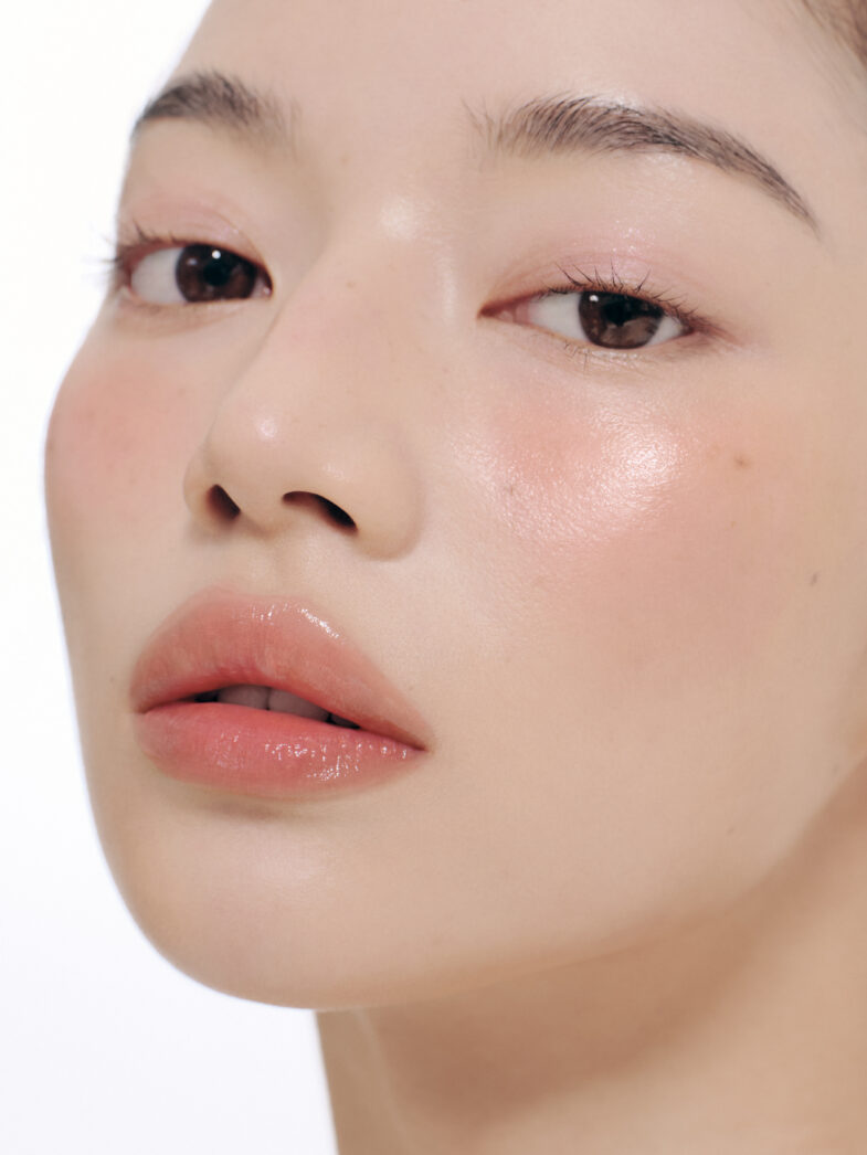 Bliski plan lica osobe s glatkom kožom koja koristi proizvode korejske kozmetike, poput Divote Cosmetics, naglašavajući prirodan i svjež izgled.