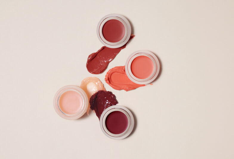Različite nijanse kremastih sjenila u staklenkama postavljene na bež pozadini, povezane s korejskom kozmetikom, brend Divote Cosmetics.